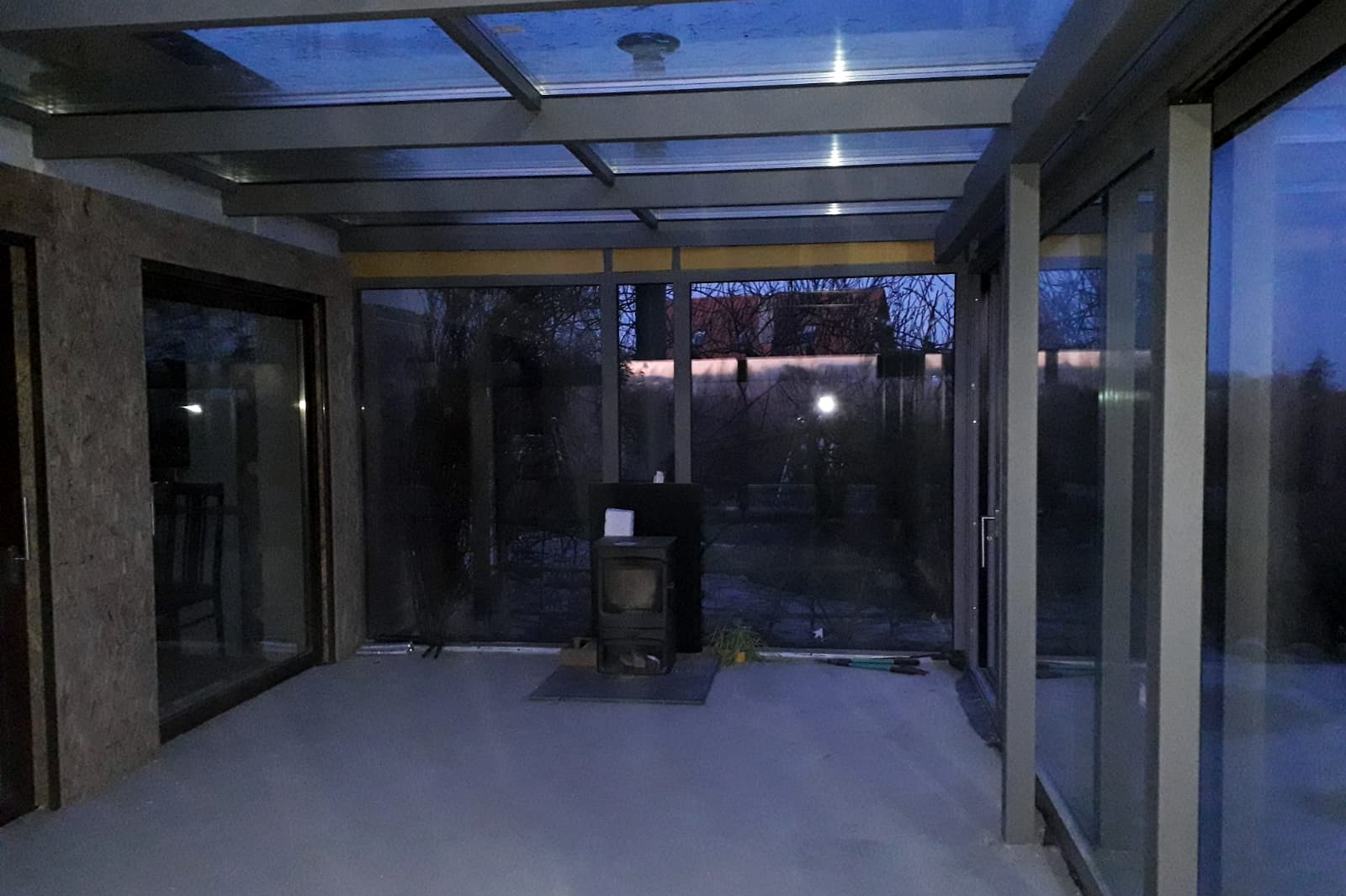 Eigen realisatie: interieur van een glazen tuinkamer met zicht op de vijver